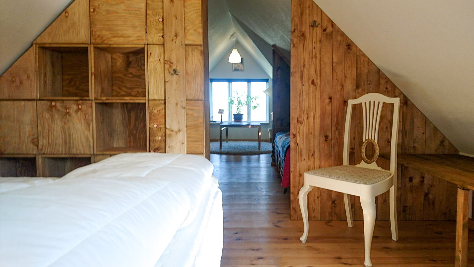 Custom made shelves devide the room to create a cozy corner for the double bed.