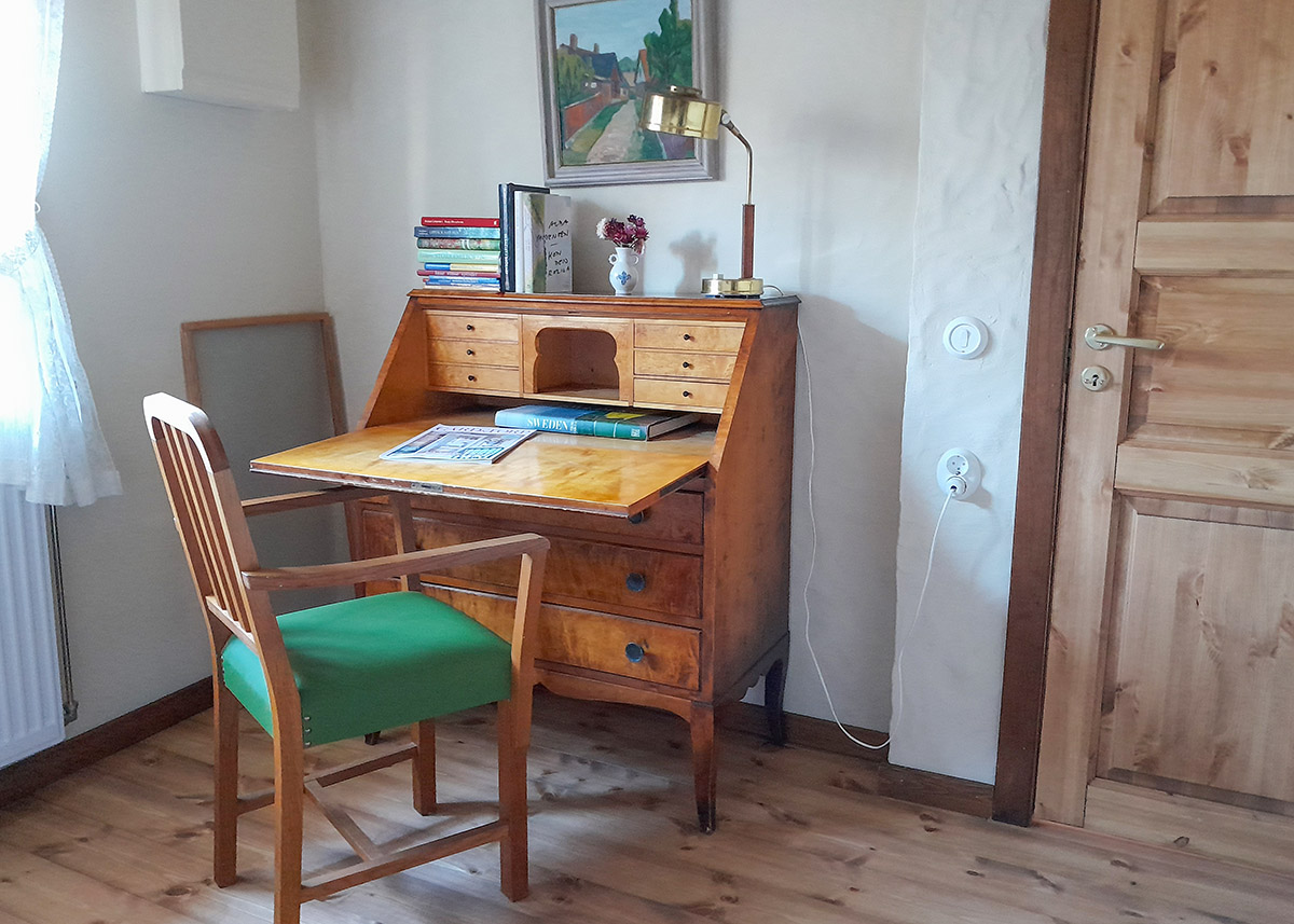 In the bedroom beside the kitchen there is a bureau and armchair.