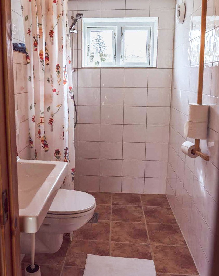 The cottage bathroom has a shower and a toilet.
