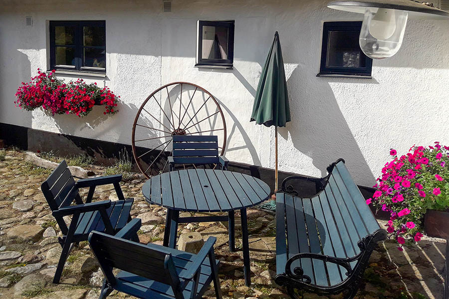 There are table, chairs and bbq-grill in the old cobblestone patio.