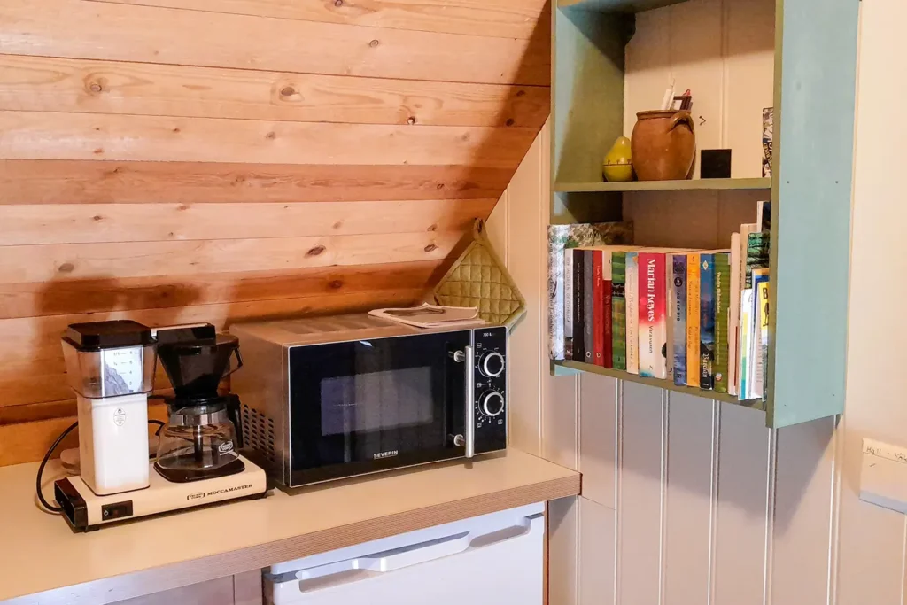Vindsrummens kök har bland annat kaffekokare, mikrovågsugn och ett kylskåp med litet frysfack.